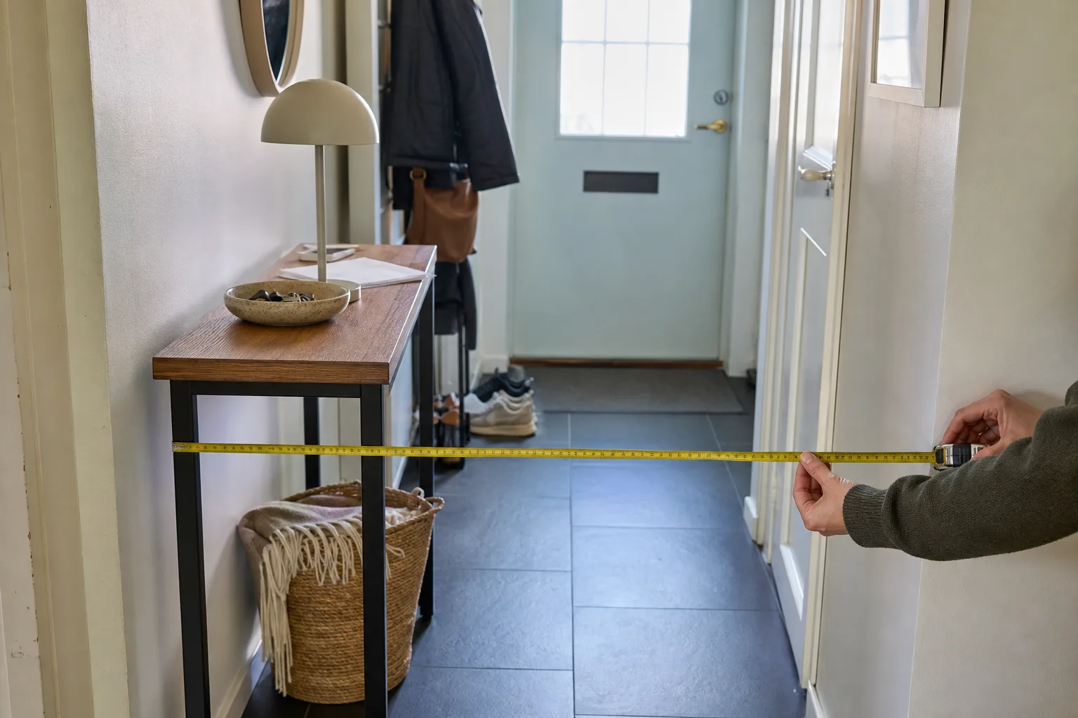 Måttband över fri gångyta framför konsolbord i smal hall